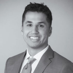 Sam Lensing headshot, smiling black and white